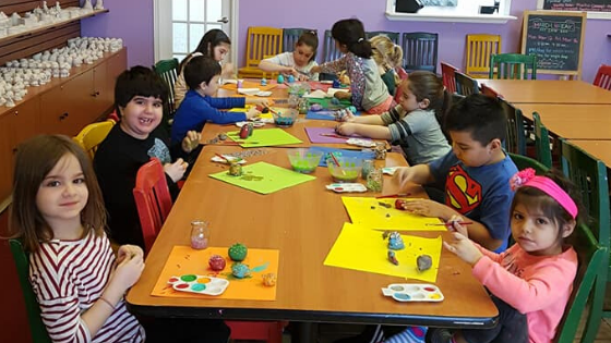 A group of young children sitting around a tableDescription automatically generated
