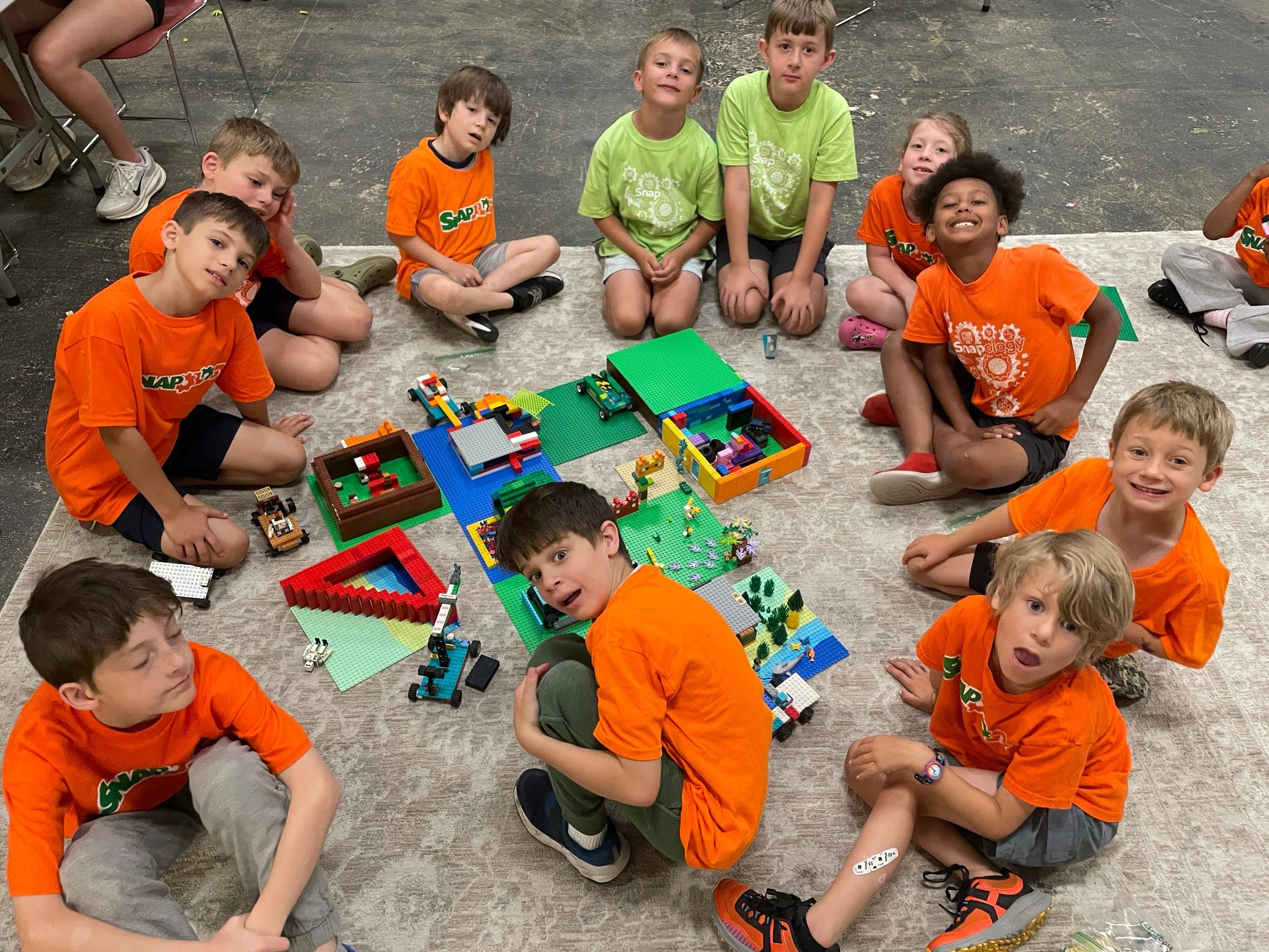 Kids building LEGO robotics creations together at a Snapology summer camp