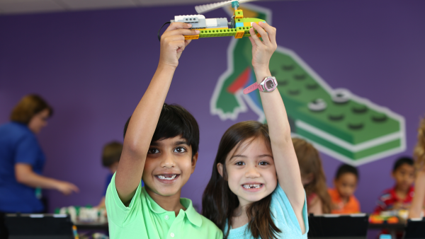 two kids holding a snapology helicopter