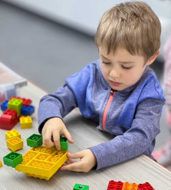 young boy building using LEGO® bricks