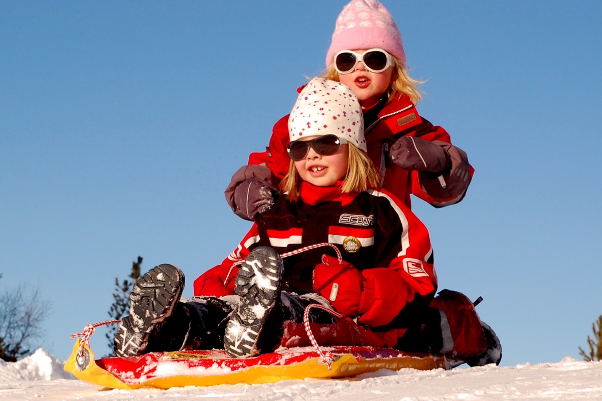 two girls on a sled in the snow