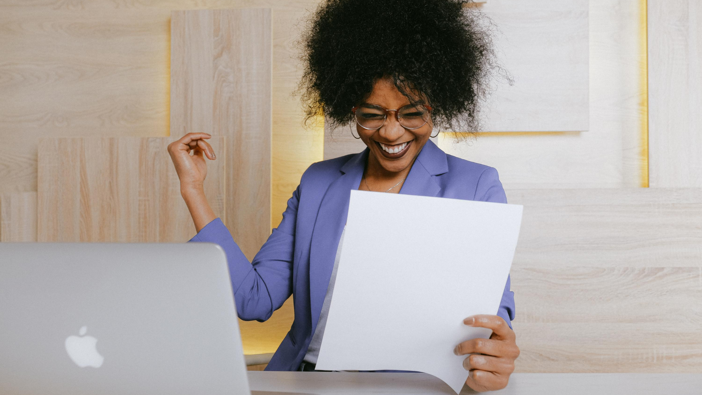 excited woman in front of a laptop