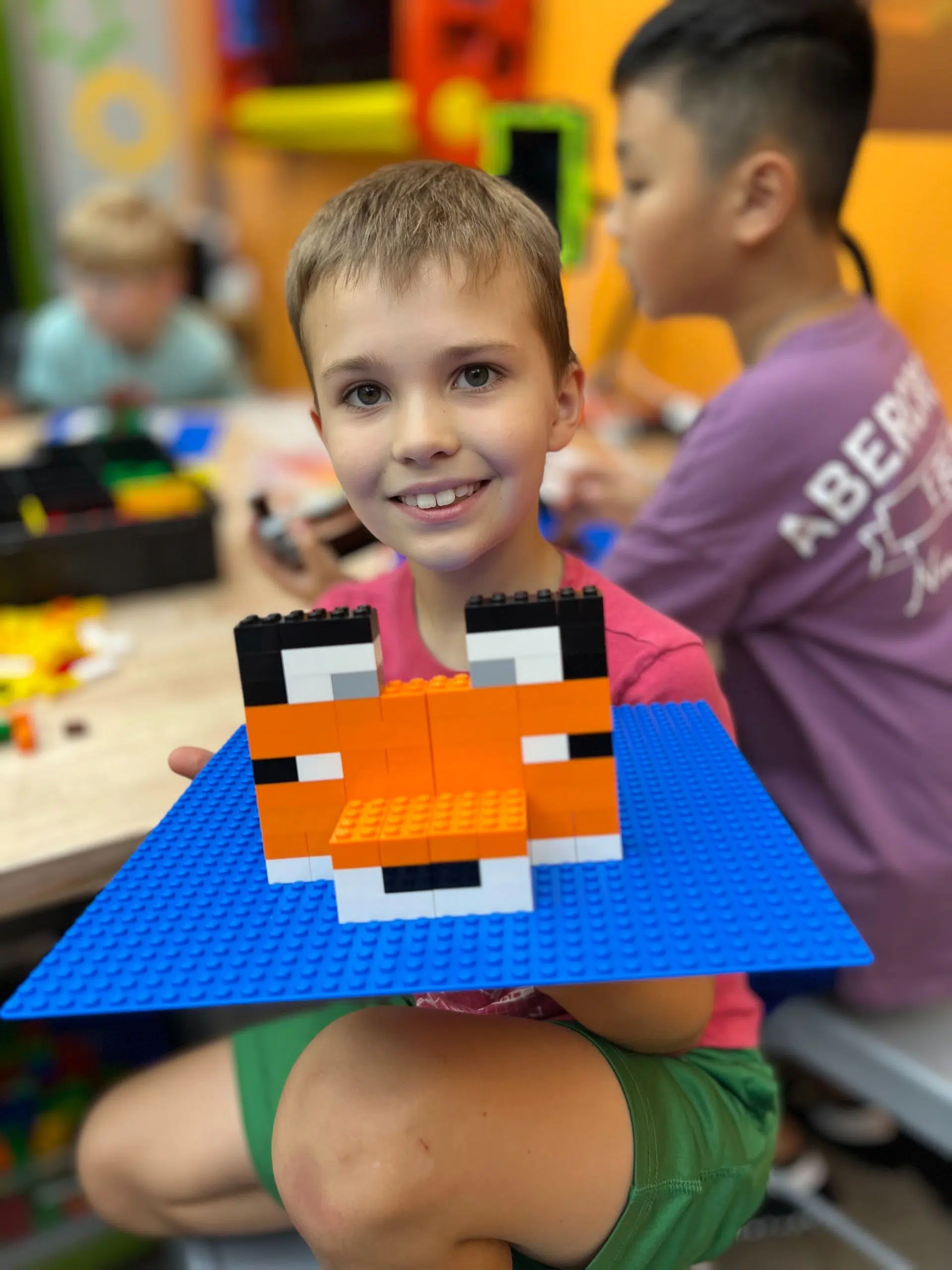 boy shows off lego camp project