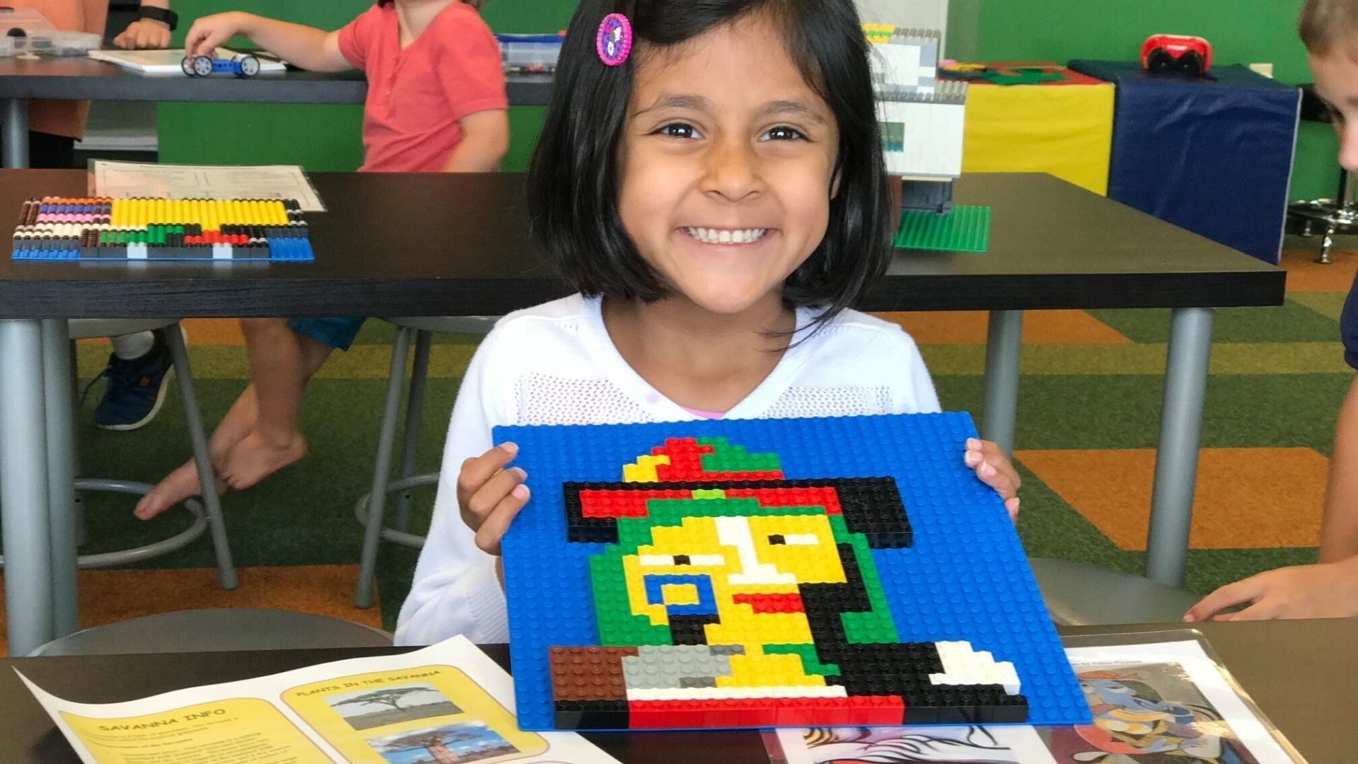 A happy child showing her creative STEAM project