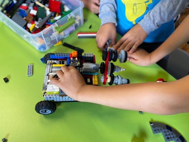 Children's hands working with Lego bricks and robotis