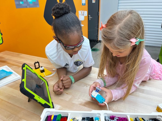 Kids working in collaboration building with Robotics