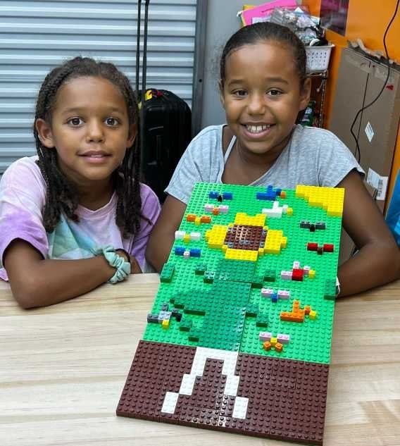 Two girls showing their creative STEAM Project